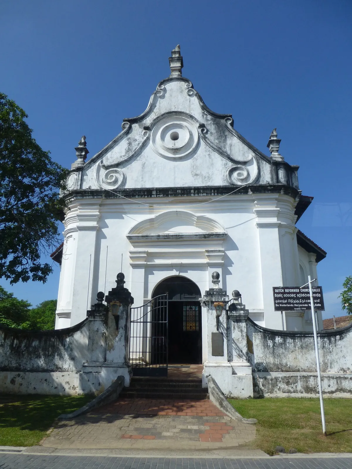 The white curved-gable front of the Dutch Reformed Church in Galle Fort under a deep blue sky