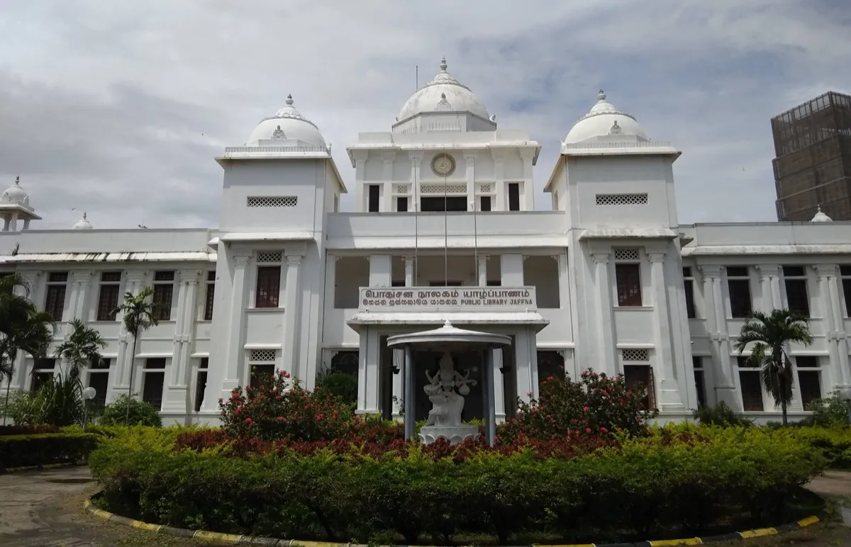 The white domed facade of Jaffna Public Library behind a circular flower bed and a white statue of Saraswati