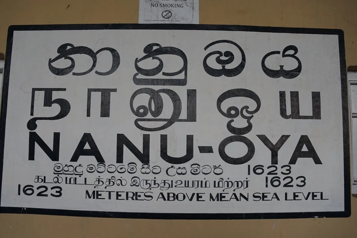 Black and white Nanu Oya station sign in Sinhala, Tamil and English, showing 1623 metres above sea level
