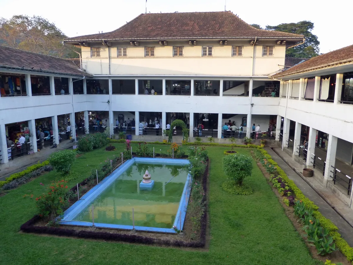 The two-storey colonial-style arcades of Kandy's covered market around a green courtyard with a pond