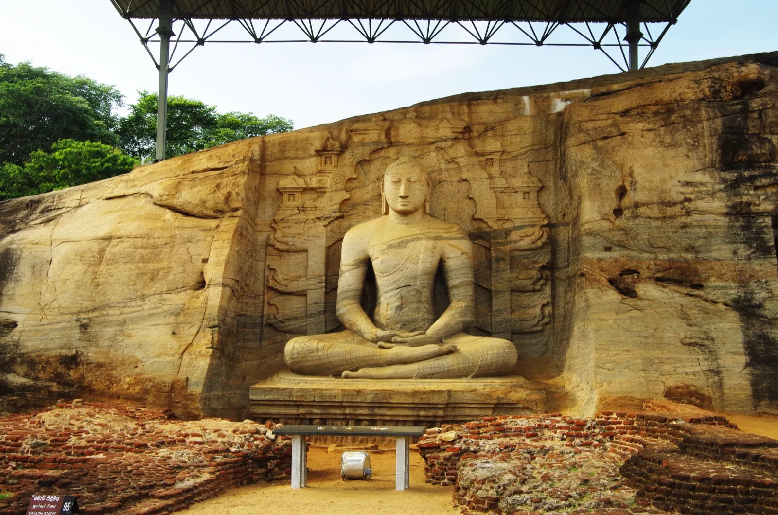 The rock-cut seated Buddha of Gal Vihara in Polonnaruwa, carved into a granite face in front of a carved shrine background