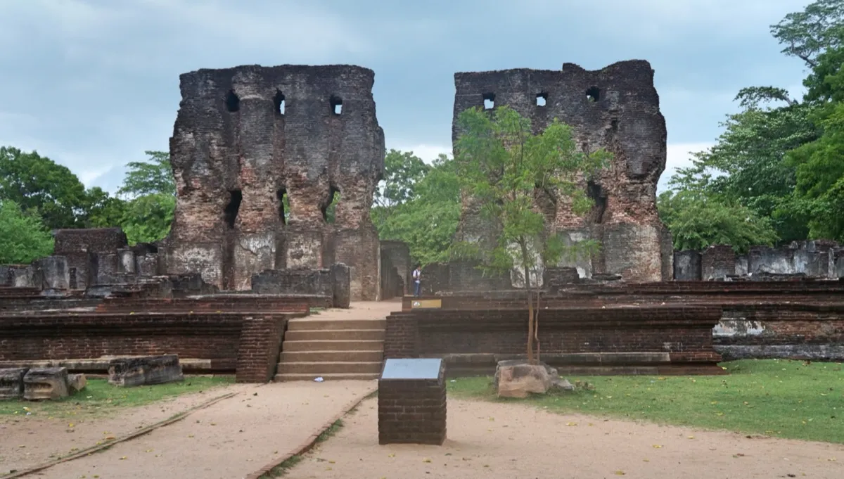 Two tall ruined brick walls of the Royal Palace in Polonnaruwa, with holes where floor beams once sat