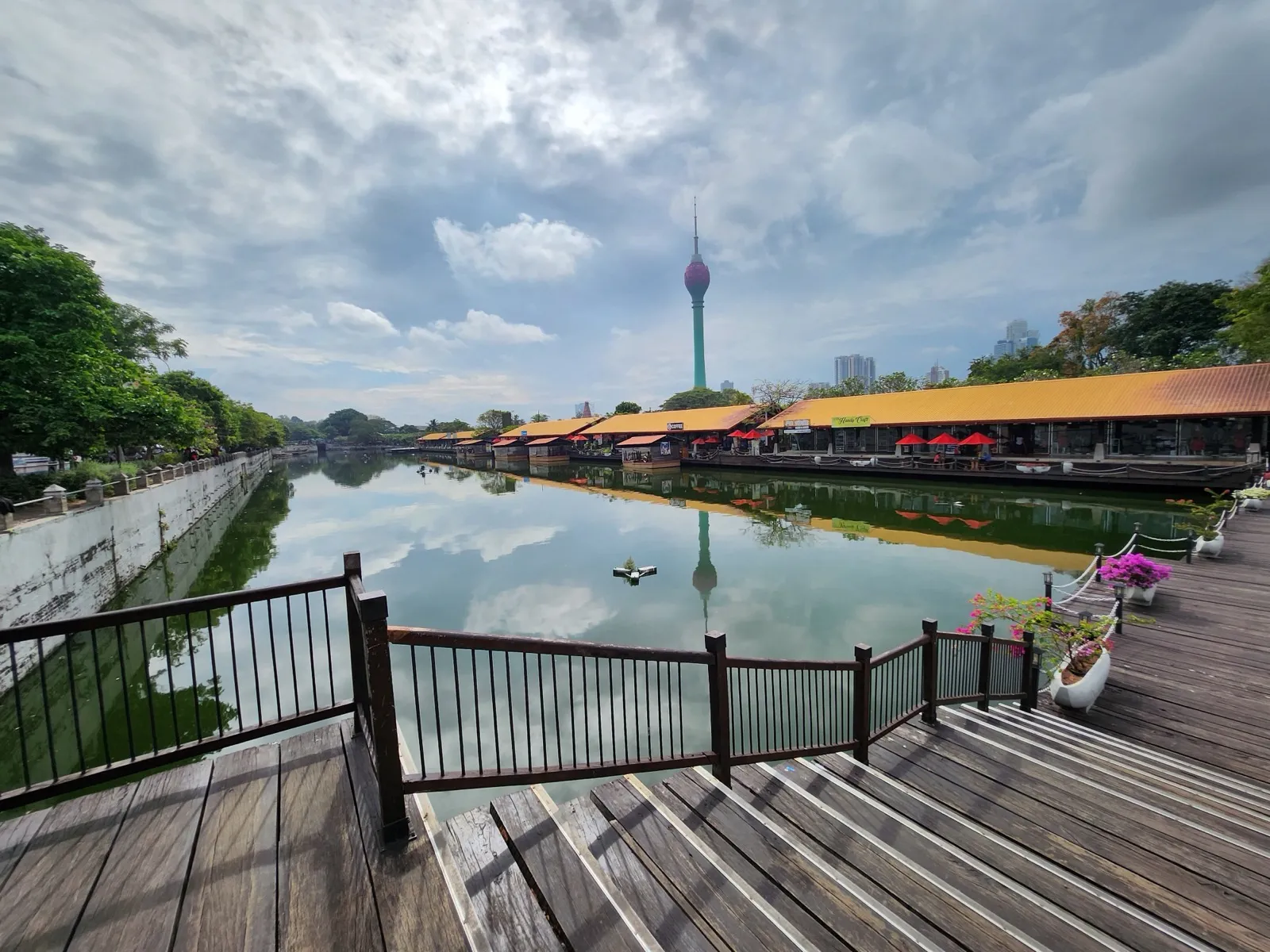 The tall green-and-pink Lotus Tower, a telecom tower in Colombo, rising beyond the Pettah Floating Market on Beira Lake