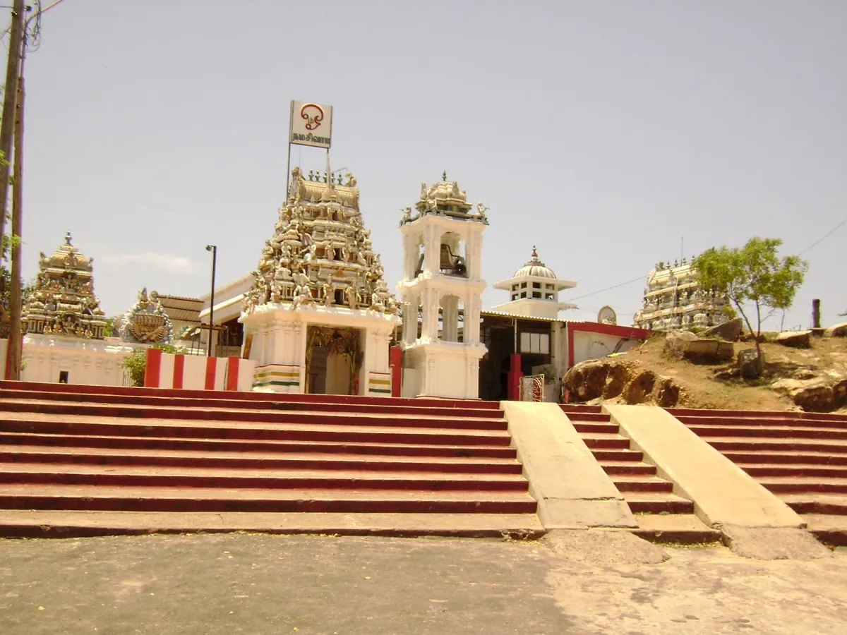 Wide red-and-white striped steps leading up to the carved white entrance tower of Koneswaram temple in Trincomalee